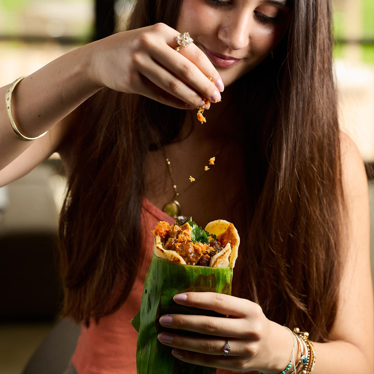 Sprinkling Sri Lankan pol sambol over a pepper beef roti