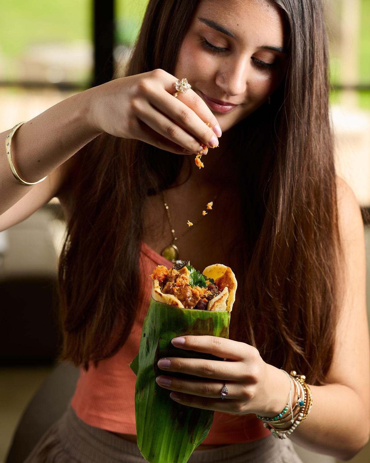 Sprinkling Sri Lankan pol sambol over a pepper beef roti